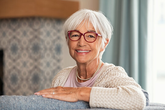 Happy senior woman wearing red spectacles at home