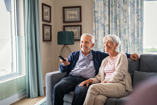 Old couple watching tv at home