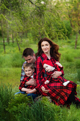 Fototapeta premium Happy family spend time together outside in green nature. International family day concept. Family look. Real people