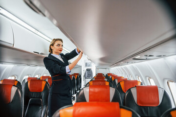 Empty seats. Young stewardess on the work in the passanger airplane