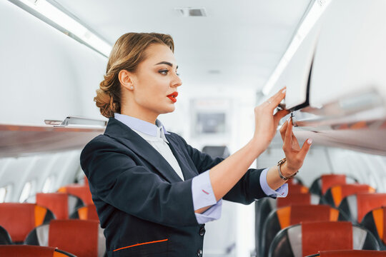 Empty seats. Young stewardess on the work in the passanger airplane