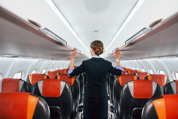 Empty seats. Young stewardess on the work in the passanger airplane