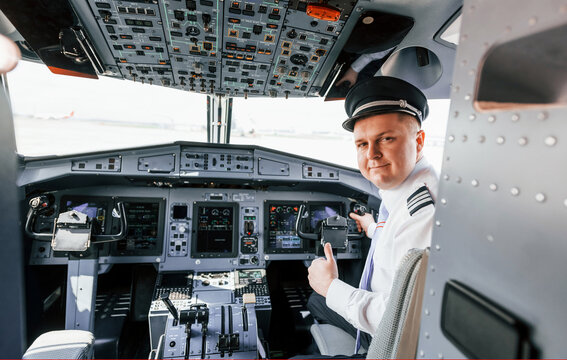 Looks behind. Pilot on the work in the passenger airplane. Preparing for takeoff