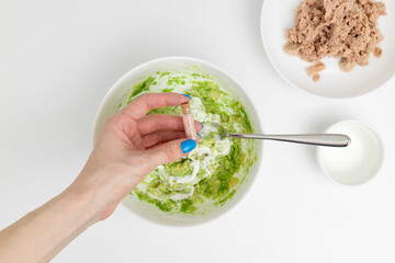 Adding spices to mashed avocado. Cooking guacamole with tuna. Step-by-step recipe.