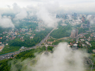 Fototapeta premium Motherland monument in Kiev between the clouds. Aerial drone view.
