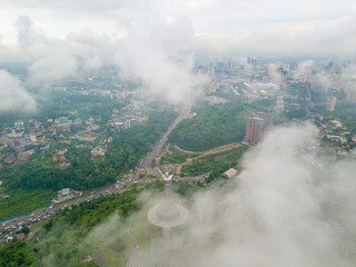 Fototapeta premium Motherland monument in Kiev between the clouds. Aerial drone view.