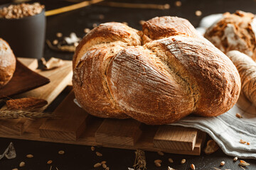 Bread on dark background. Fresh crispy baking, old style. © Exploder