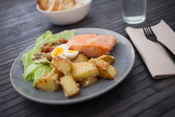 steamed salmon fillet with potato wedges, guacamole homemade and quail egg