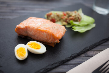 baked salmon fillet with homemade guacamole and quail eggs halves