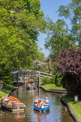 Little electric boats going through the historic canal of Giethoorn, Netherlands