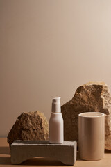 White ceramic opaque bottle on a beige background without labels on natural podium, stones and...