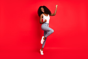 Full length photo of young attractive black girl happy positive smile rejoice win victory isolated over red color background