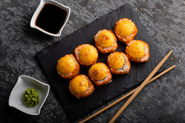 Fresh sushi roll set. Sushi rolls california with cheese. Sushi on black background, chopsticks, wasabi, soy.
