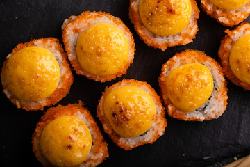 Fresh sushi roll set. Sushi rolls california with cheese. Sushi on black background, chopsticks, wasabi, soy.