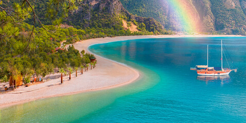 Brown gulet anchored with rainbow at the Aegean sea - Panoramic view of Oludeniz Beach And Blue Lagoon, Oludeniz beach is best beaches in Turkey - Fethiye, Turkey