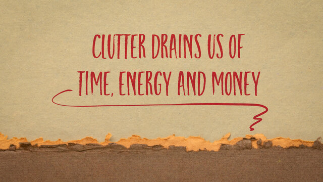 clutter drains us of time, energy and money, decluttering concept - handwriting on handmade paper