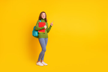 Full length body size photo smiling girl in casual clothes keeping book pile backpack isolated vivid yellow color background