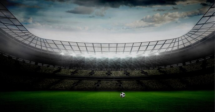 Composition of football on football pitch with spotlights in sports stadium