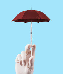 Vaccination concept design. Banner, vaccination time. Umbrella shaped syringe with grafting. The way to avoid the virus. Vaccination against epidemic diseases. Red umbrella, blue background. © fatihaydin