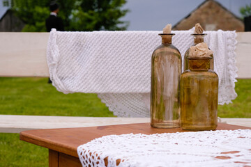 Three vintage glass bottles with paper corks on a rustic yard background. 