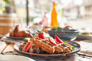 Fototapeta premium Traditional Belgian dessert - waffle with strawberry and cream.