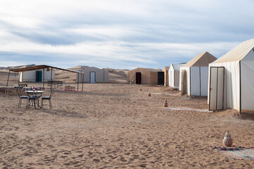 berber camp in endless expanses of the Sahara huge sand dunes at dawn of sunrise