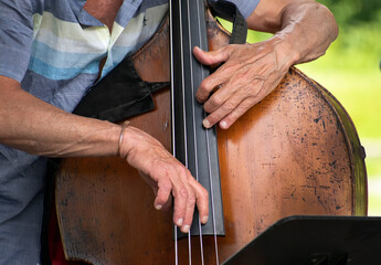 Close-up of jazz bass player's hands playing upright bass.