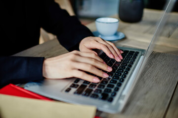 Fototapeta na wymiar Faceless lady working remotely on laptop in street cafe