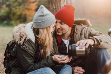 Travel couple camping with map in the forest. Concept of trekking, adventure and seasonal vacation.