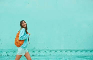 Total blue mint color style, joyful asian woman walking over blue background