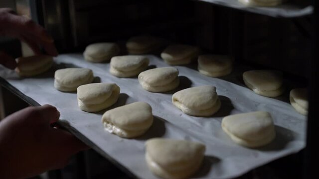 Professional Chef making Bao buns from scratch - putting the buns tray in the combi oven to make Gua Bao in commercial kitchen setting.