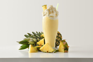 Pineapple milkshake with cream decorated with fruit on table isolated