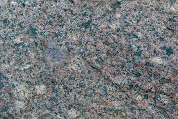 The texture of the old stone. Granite. Variegated colors, natural background. Horizontal photo. 