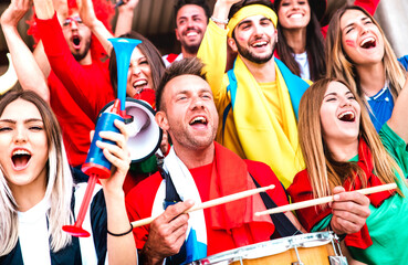 Football supporter fans cheering with drums watching soccer cup match at stadium bleachers - Young...