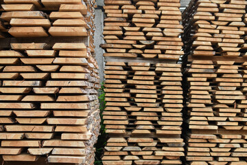 Unedged board of soft wood stacked in the open air. Selective focus.