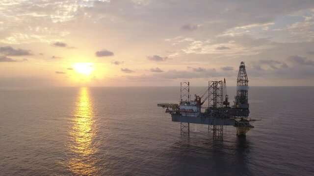 Aerial view of the jack up rig shot during sunset time. Fly around the jack up rig with a drone.
