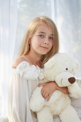 Little girl in white chiffon tent with toy