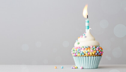 Birthday cupcake with pastel colored sprinkles and a candle
