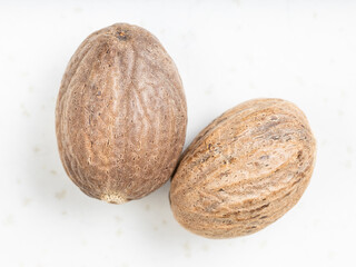 top view of two whole nutmeg fruits on gray