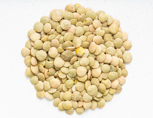 pile of raw light green lentils close up on gray