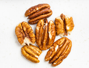 several shelled pecan nuts close up on gray