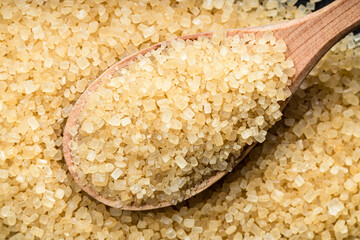 spoon with demerara brown cane sugar on pile