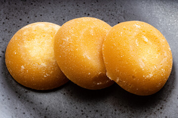 few whole round pieces of palm sugar on black