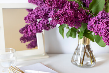 Bouquet of Violet lilac in a vase on the dressing table. Close up