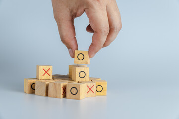 Hand hold wooden block. OX game or Tic Tac Toe wooden box. Business marketing strategy planning...