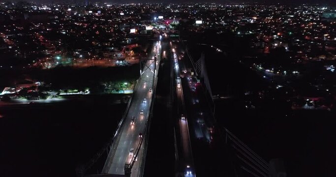 Low speed aerial view over Juan Pablo Duarte and Juan Boch Bridge at night, Santo Domingo