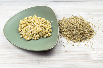 raw freekeh wheat grains and boiled porridge