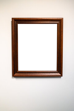 vertical wide dark brown picture frameon gray wall