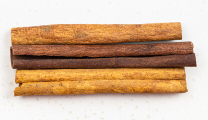 three sticks of cassia cinnamon close up on gray