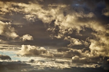 Obraz premium Bright colorful thunder clouds in the sunset light. Picturesque clouds in the evening light. Colorful abstract high contrast sunset sky. Dramatic sky. Abstract backgrounds and textures.